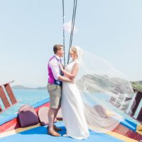 Bride wearing Laverne wedding dress by Catherine Deane and groom on a boat in Nidri | Maxeen Kim Photography