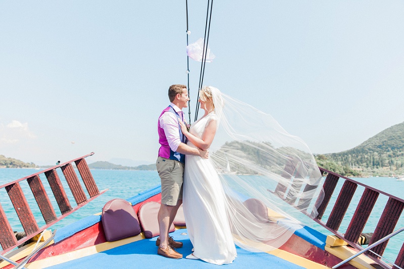 Bride wearing Laverne wedding dress by Catherine Deane and groom on a boat in Nidri | Maxeen Kim Photography