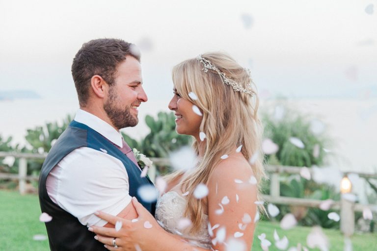 Bride and groom embracing under a shower of confetti on Kefalonia