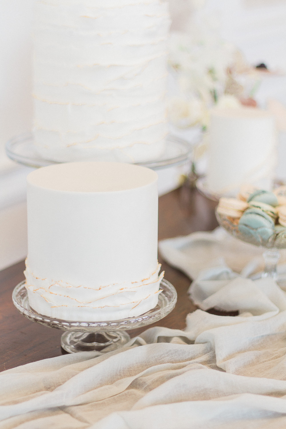 Dessert table with white cakes with gold edging by Anna Lewis at Froyle Park wedding venue in the UK