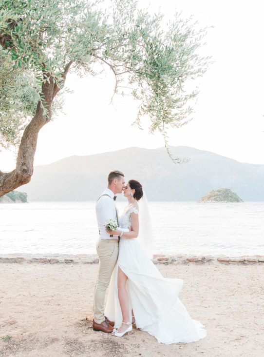 Bride and groom kissing on the beach at their Ithaca wedding