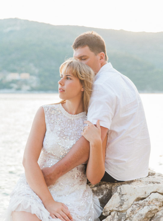 Bride and groom sitting on rocks at their Lefkada wedding
