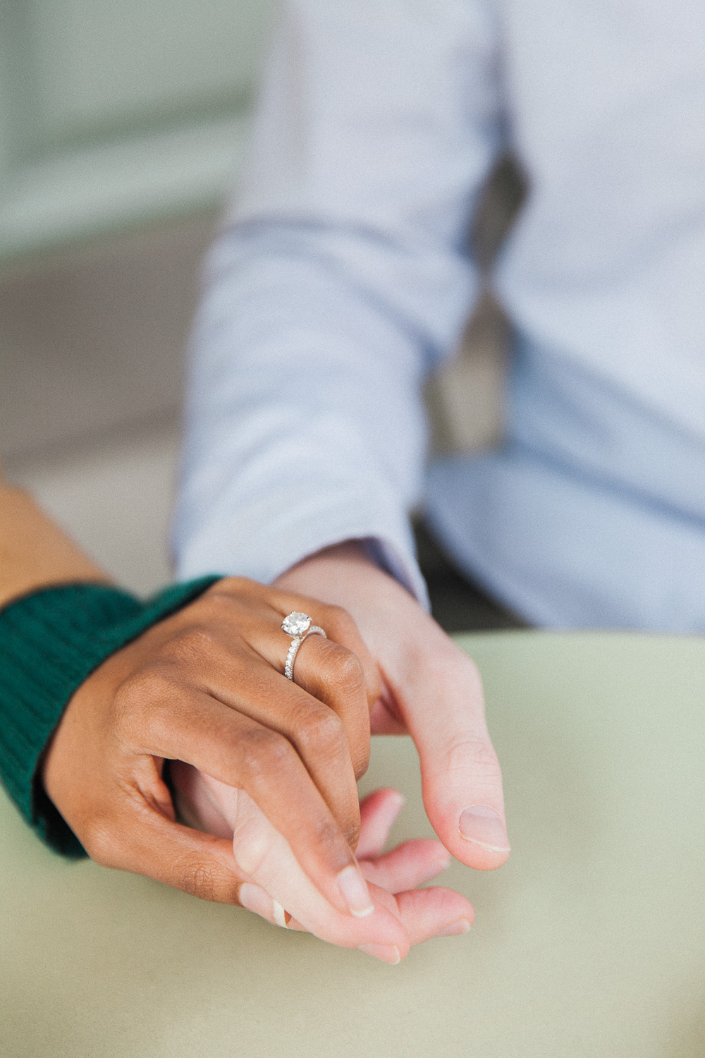 Couple holding hands showing off the brides diamond Tiffany engagement ring