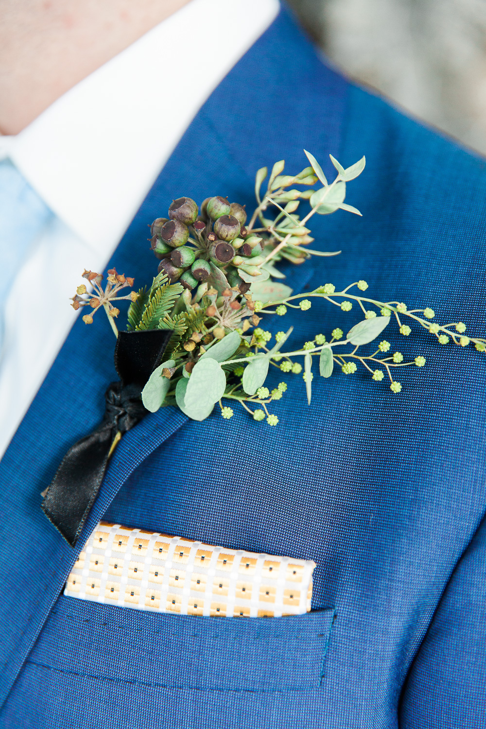 Green foliage buttonhole with white and gold pocket square