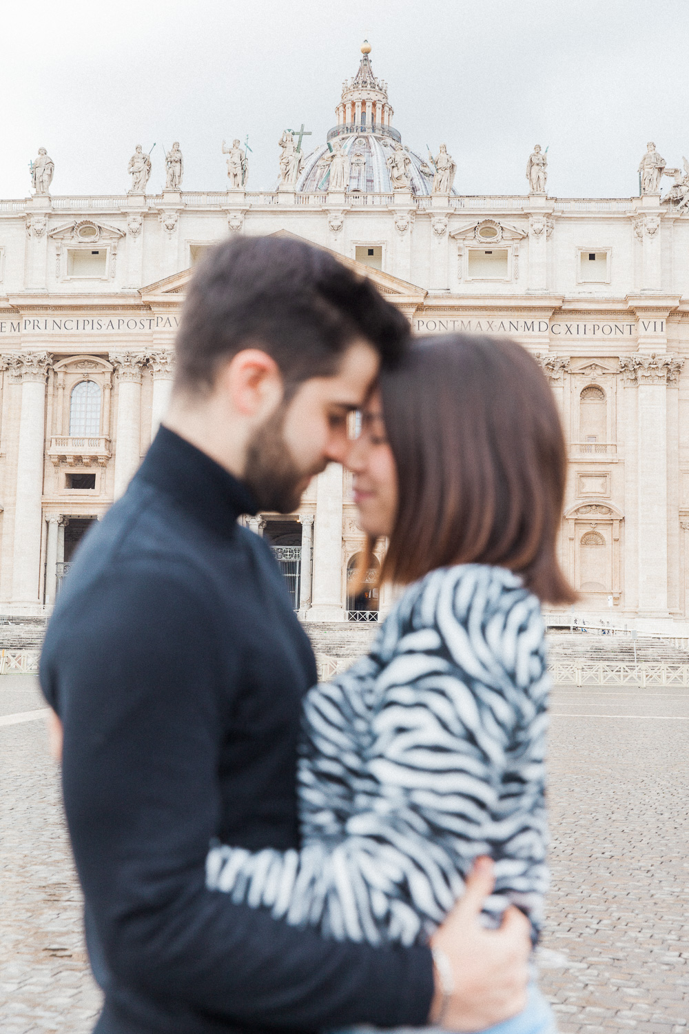 Couple hugging in front of Sait Peter's Basilica in Rome, Italy