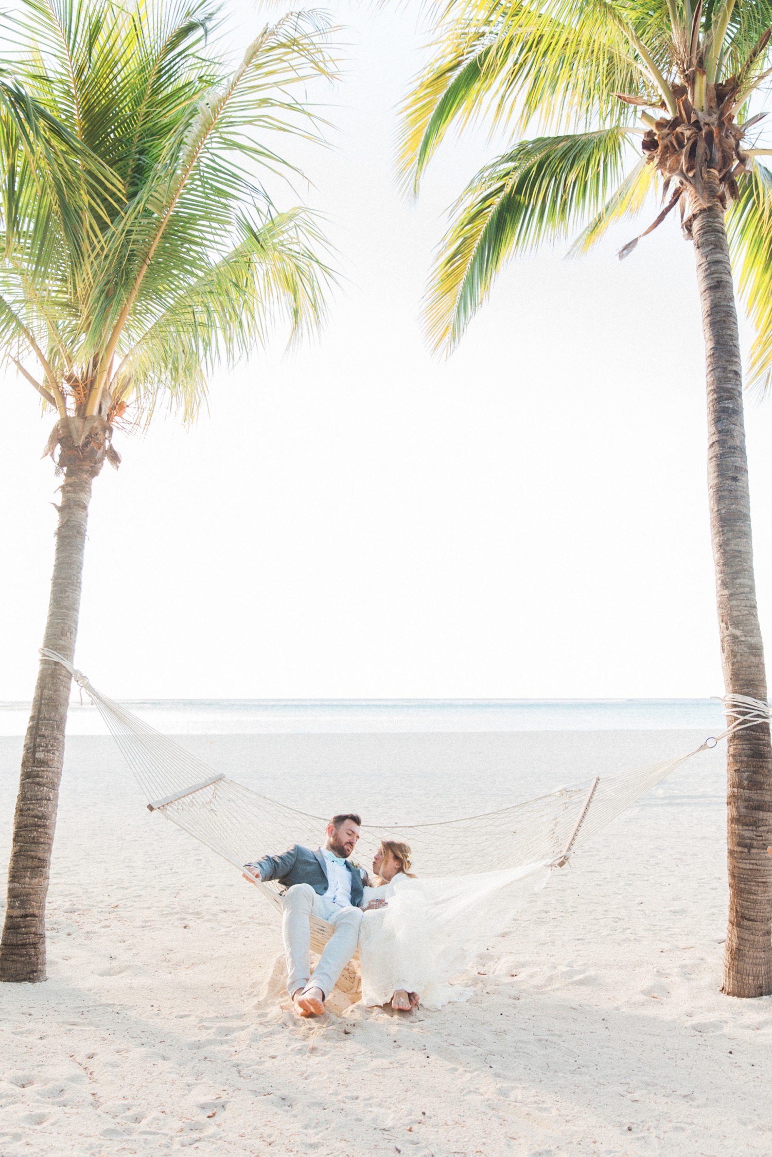 Bride and groom relax in a hammock on the day of their Mauritius wedding