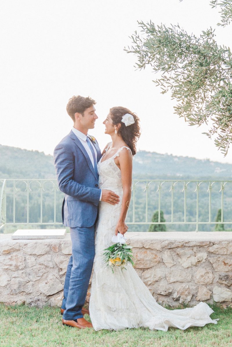 Bride and groom standing under an olive tree at their wedding in Ithaca, Greece