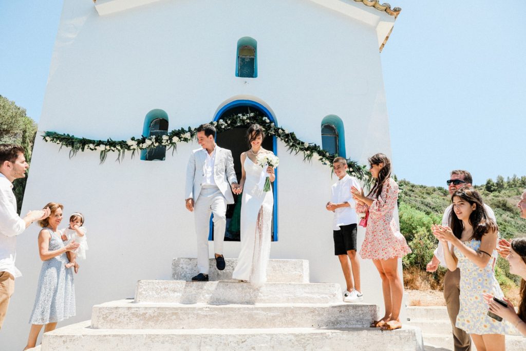 Guests celebrate as newly married couple exit Agios Andreas church on Ithaca