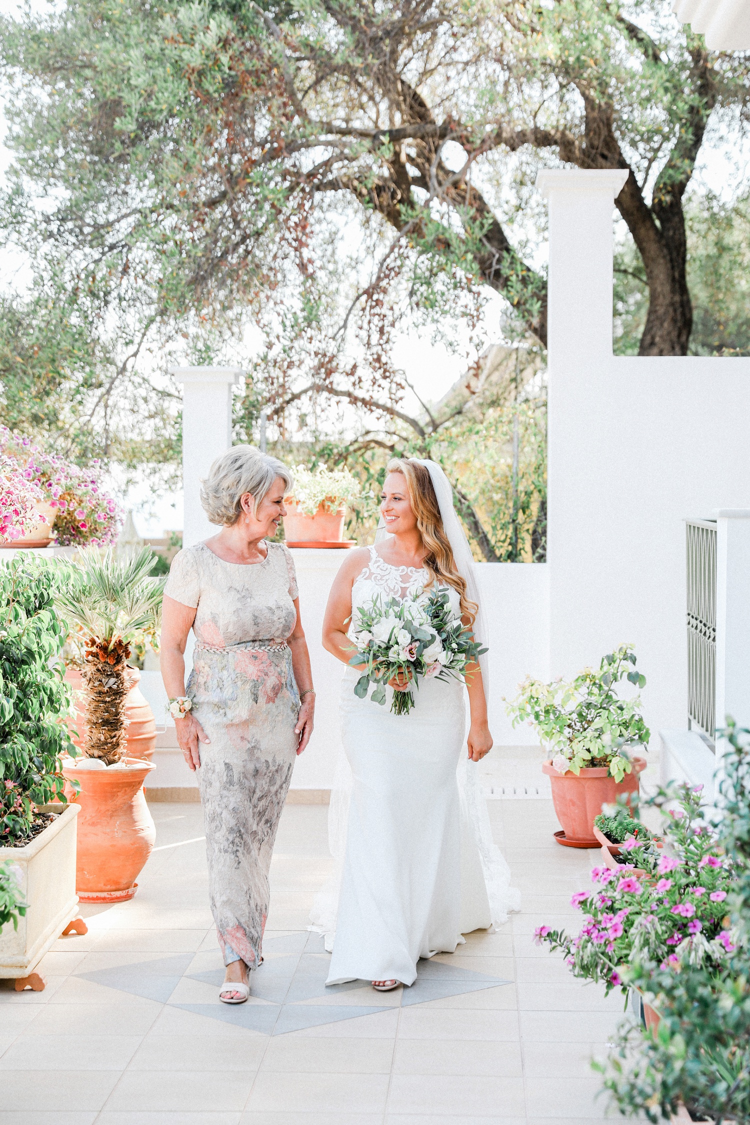 Bride and her mother walk along the terrace at Irida Boutique Hotel
