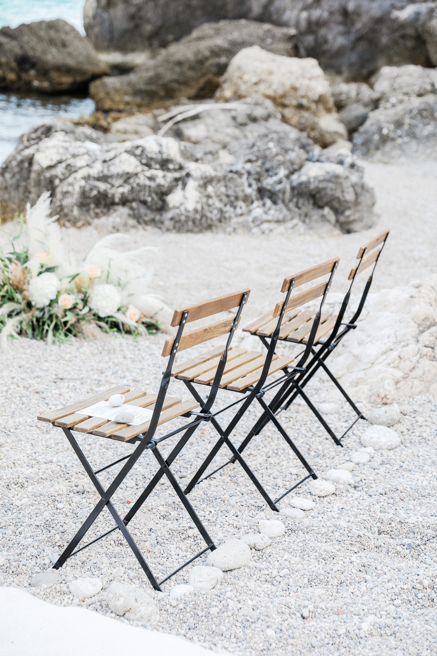 Wooden chairs at a beach wedding ceremony in Parga