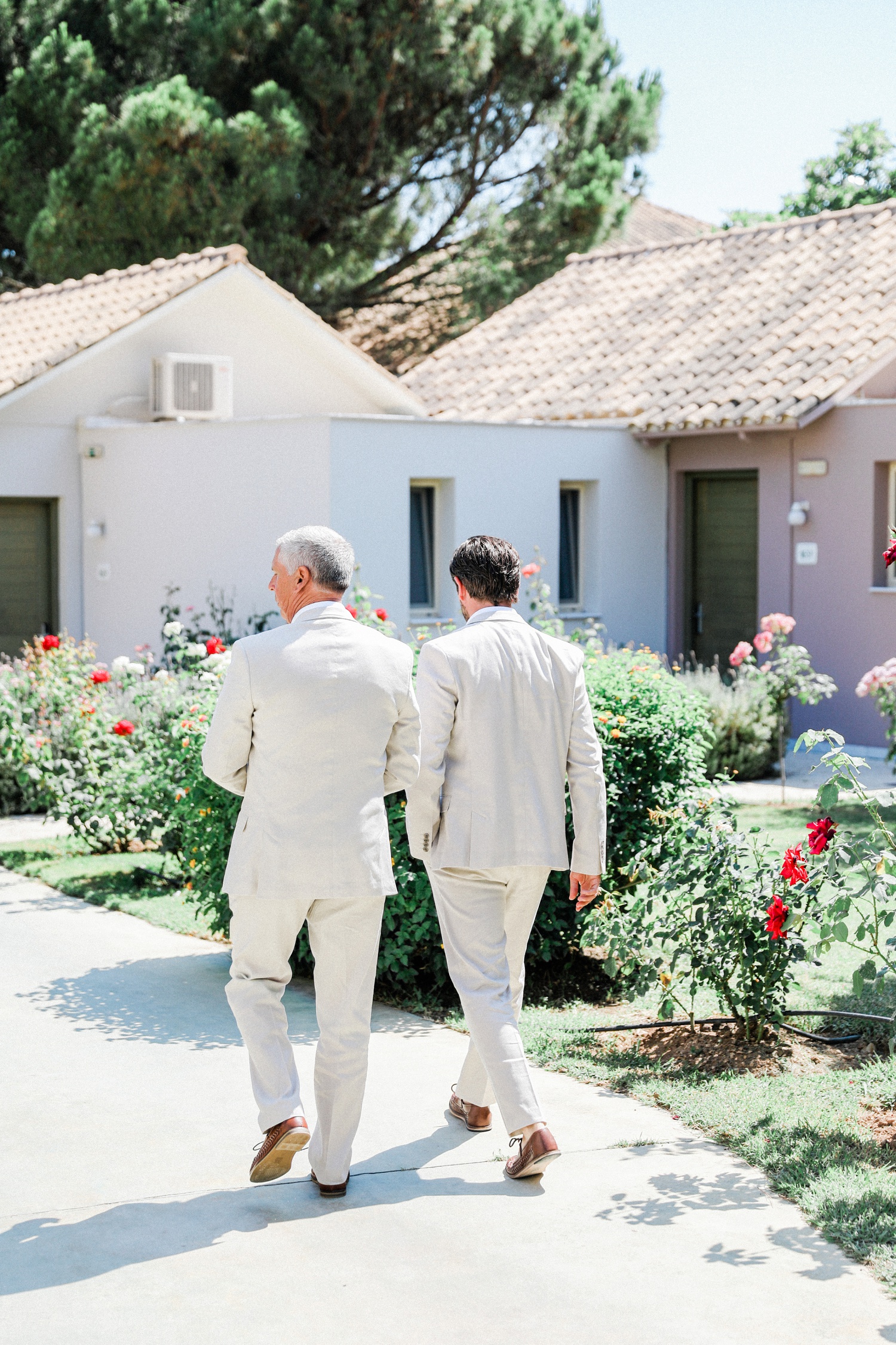 Groom and his father walk through Parga Beach Resort in Greece