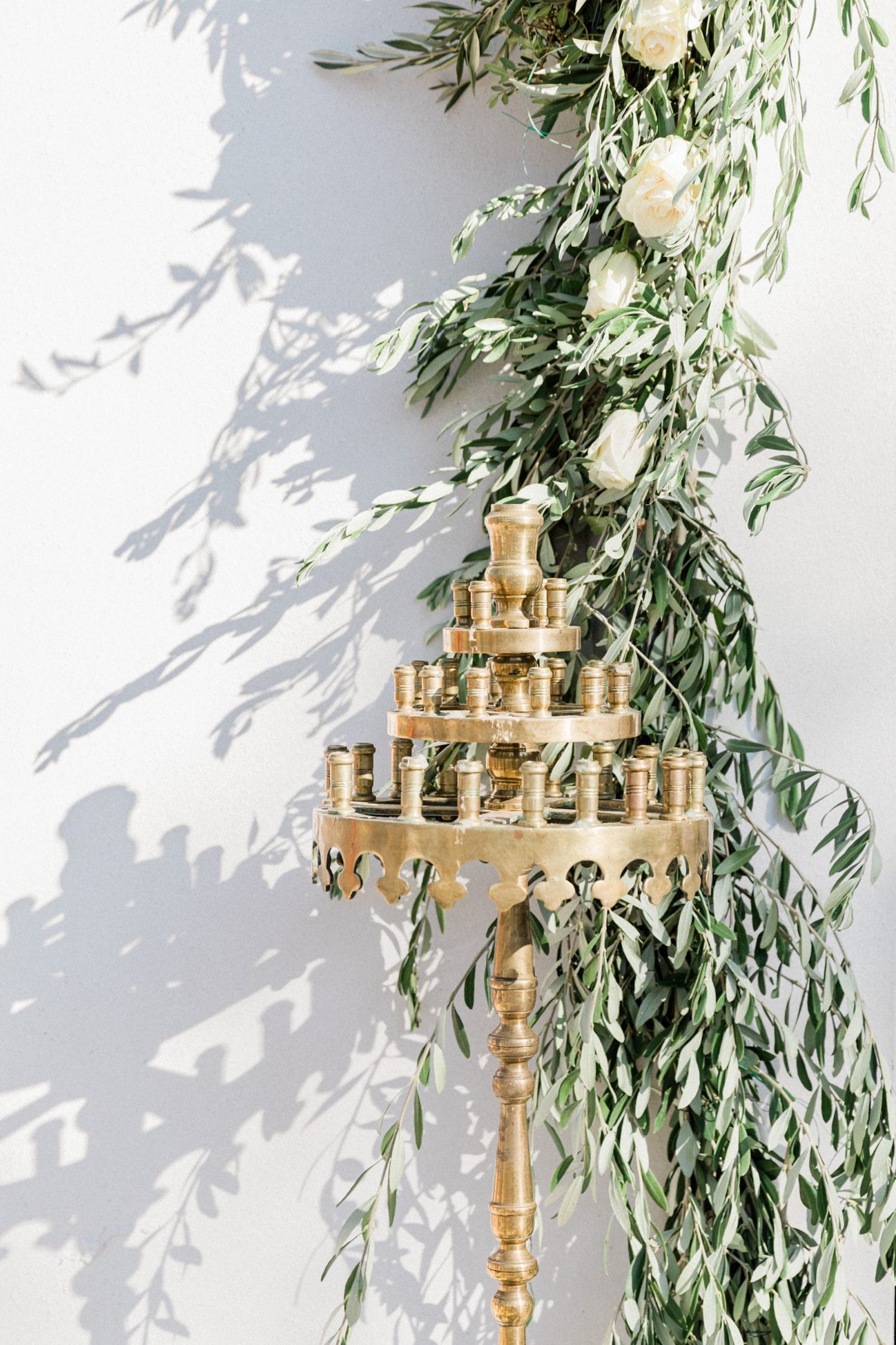 Gold candle holder and olive and white rose garland at the door of the church on Lazaretto Islet