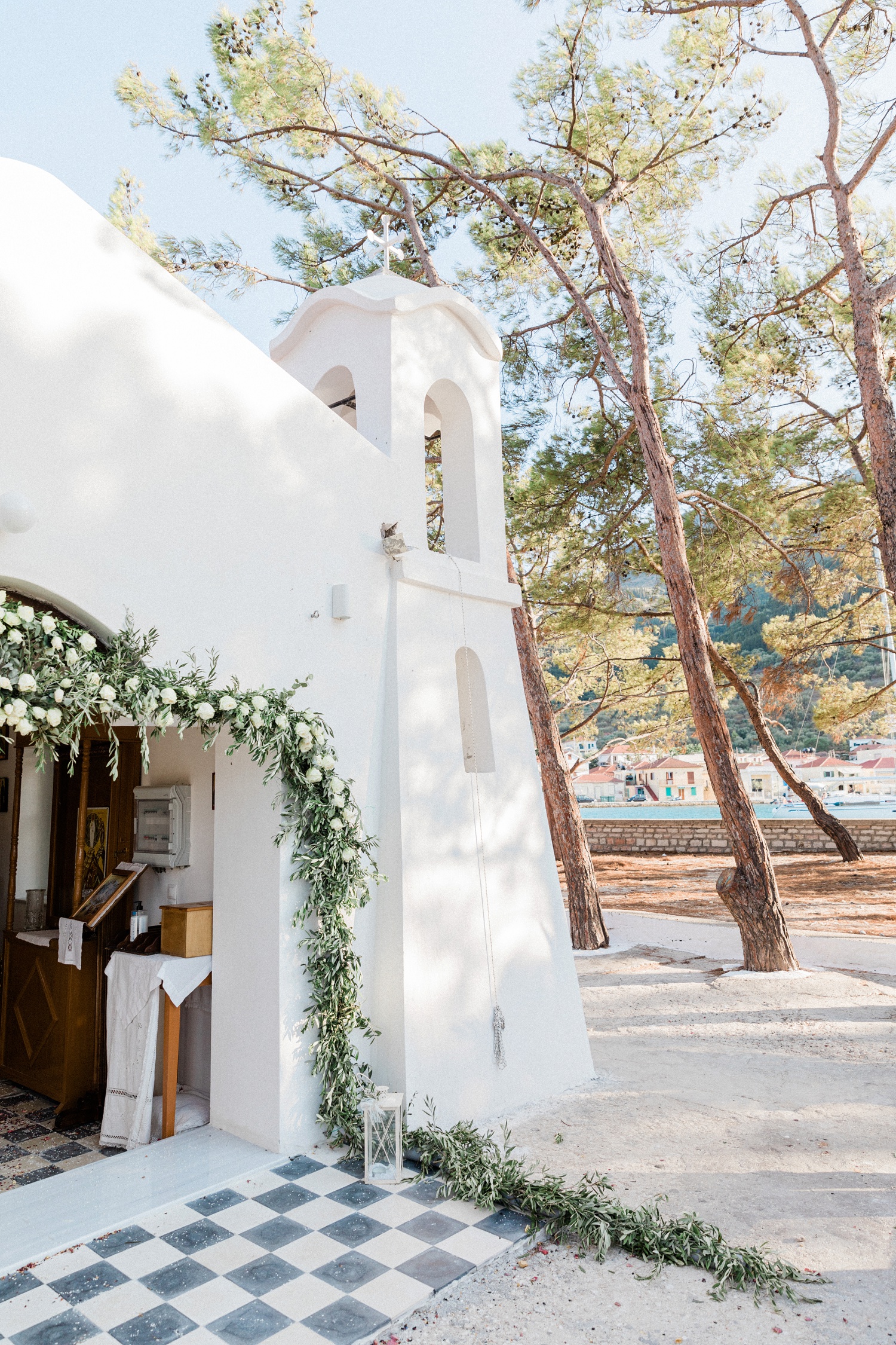 White church door on Lazaretto Islet decorated with garlands of olive leaves and white roses