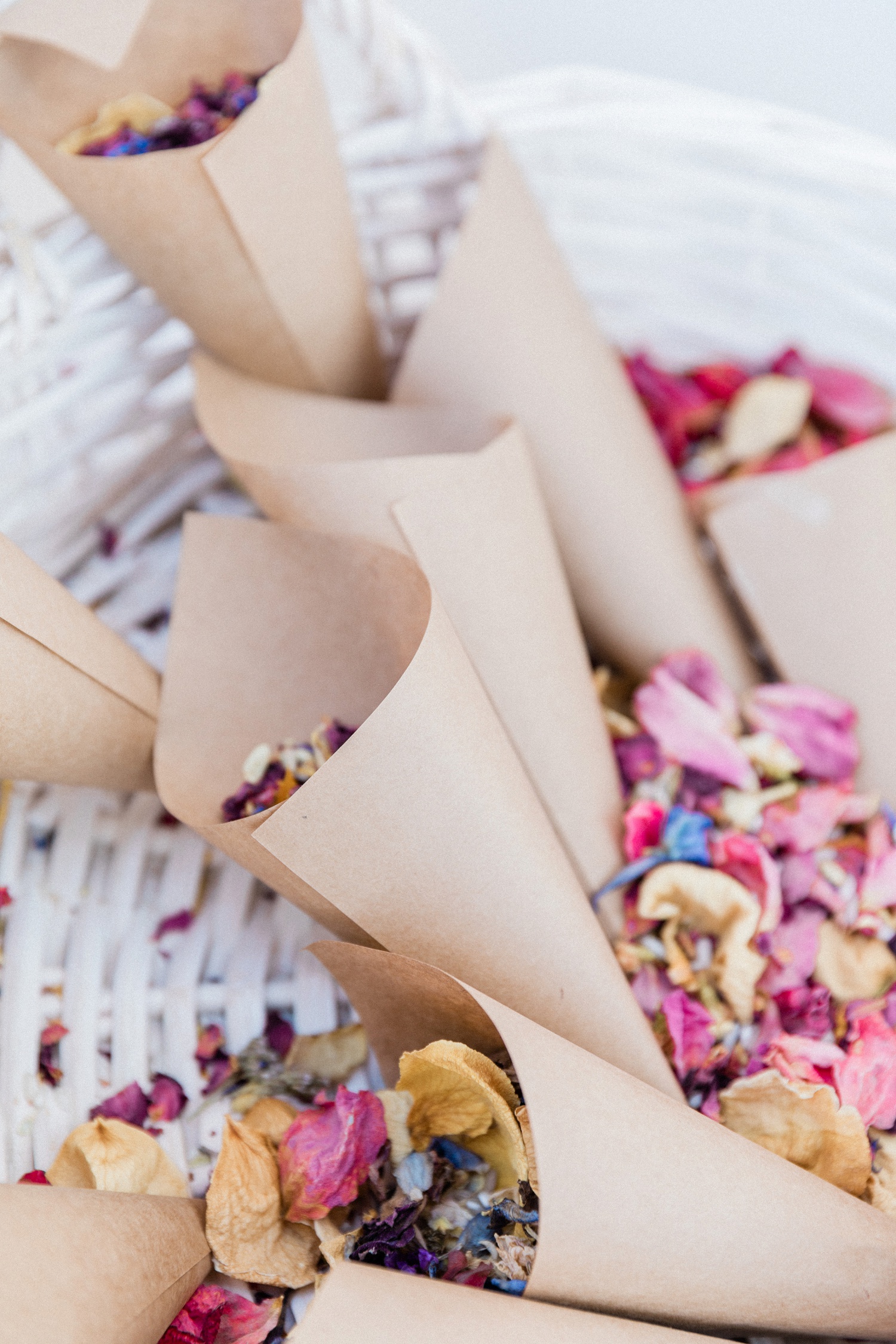 Confetti cones filled with pastel dried flowers in a white basket 