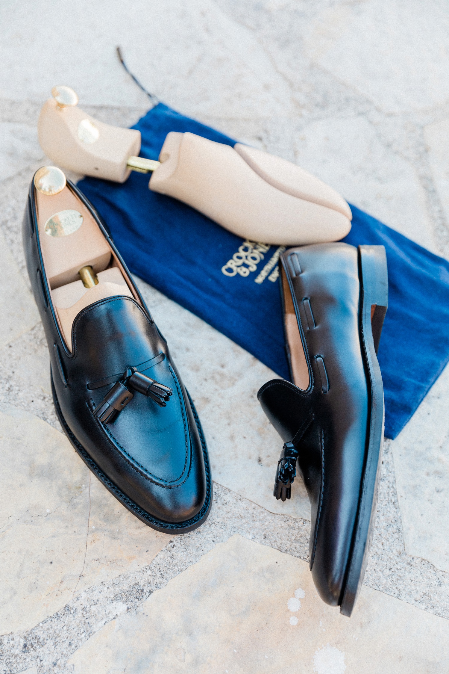 Grooms Crockett and Jones loafers on a blue branded shoe bag