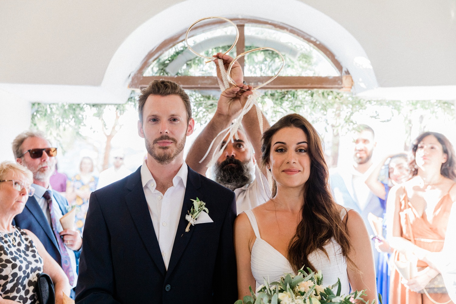 Couple during the Greek wedding crown ritual of their Orthodox wedding ceremony in Ithaca