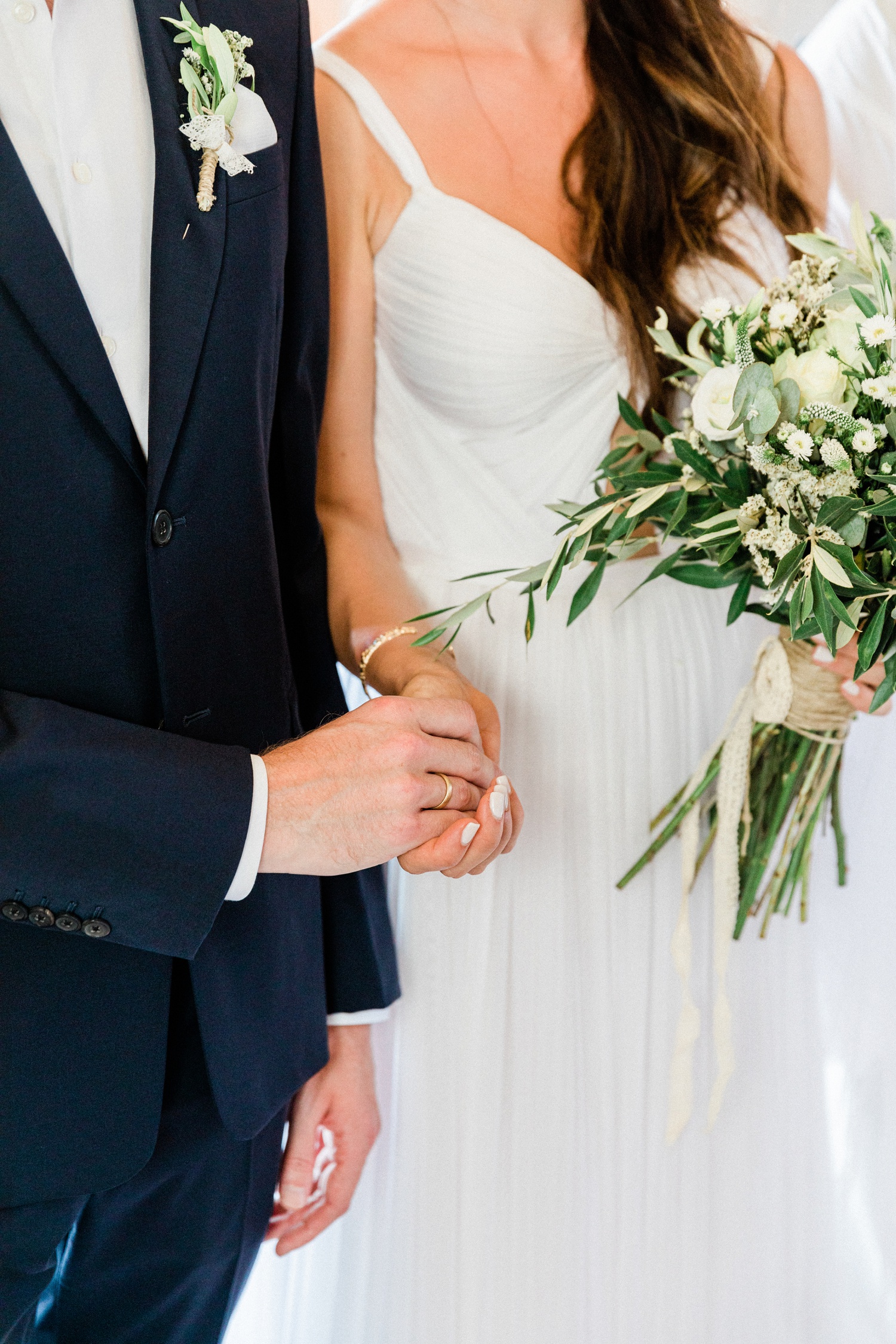 Couple hold hands during their olive grove wedding in Greece