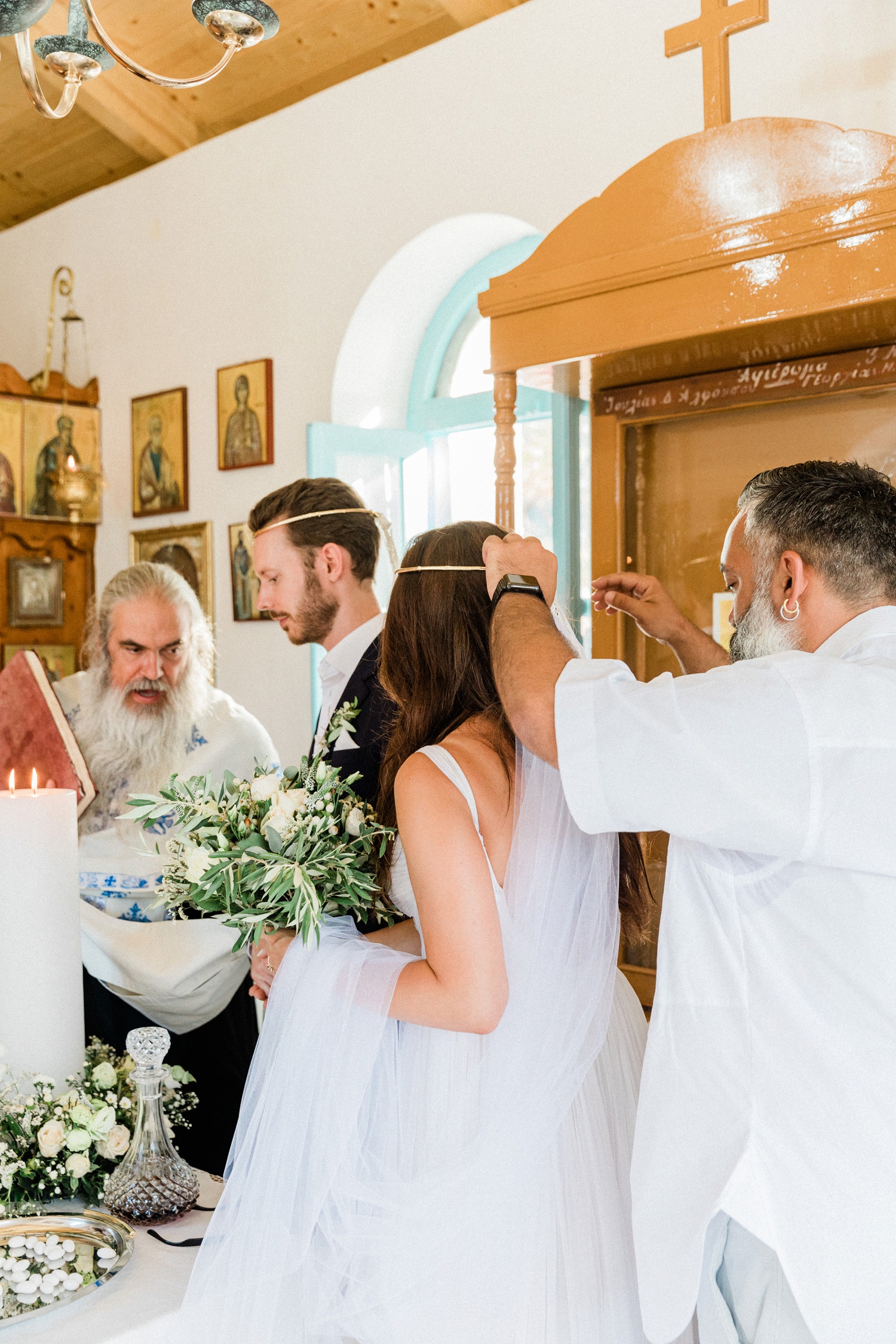 The couple, priest and best man circle the alter during their Orthodox wedding ceremony in Ithaca