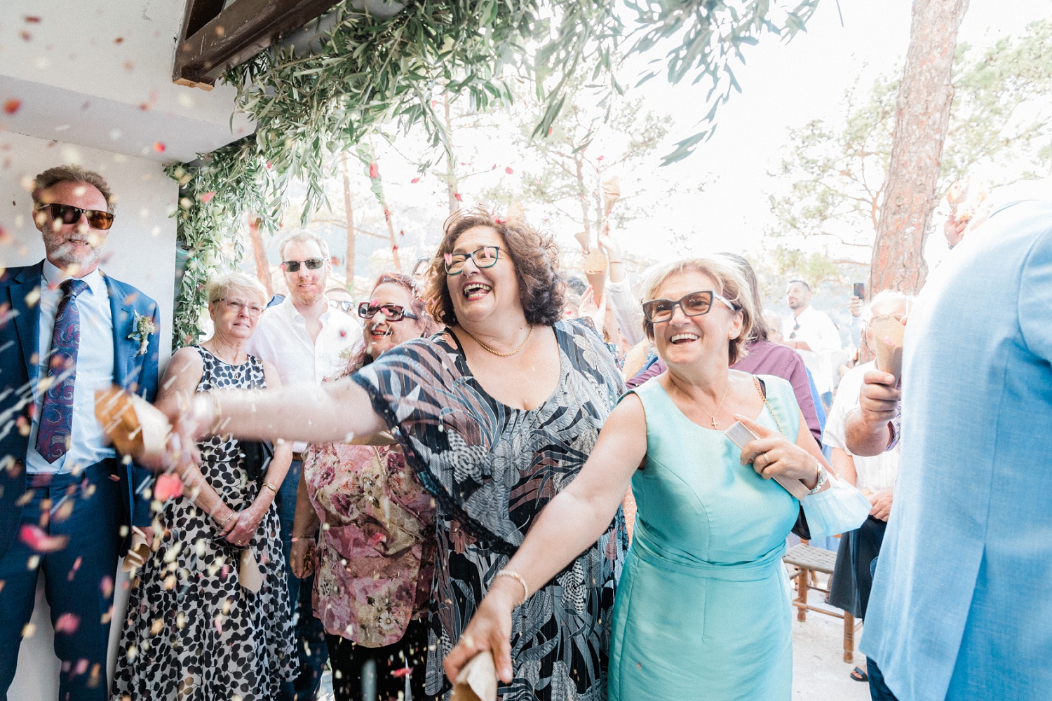 Guests shower the bride and groom with confetti during their olive grove wedding on Ithaca