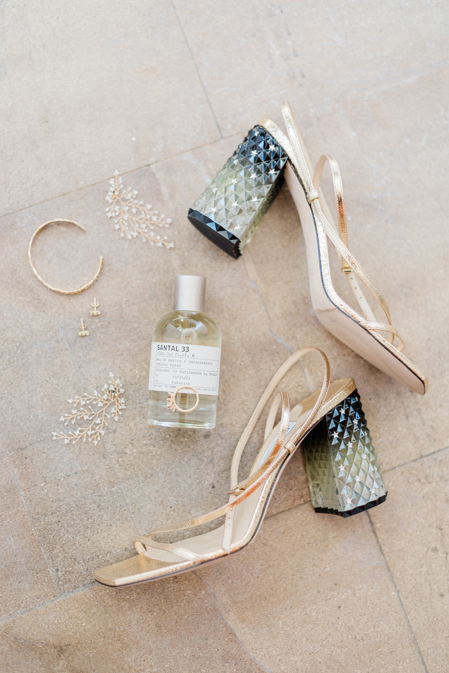 Flatlay of brides details including a Le Labo fragrance, Jimmy Choo heels and a Ruth Tomlinson engagment ring