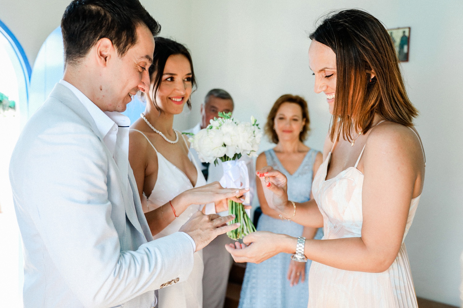 Maid of honour performs ring exchange ritual during a Greek Orthodox wedding ceremony on Ithaca