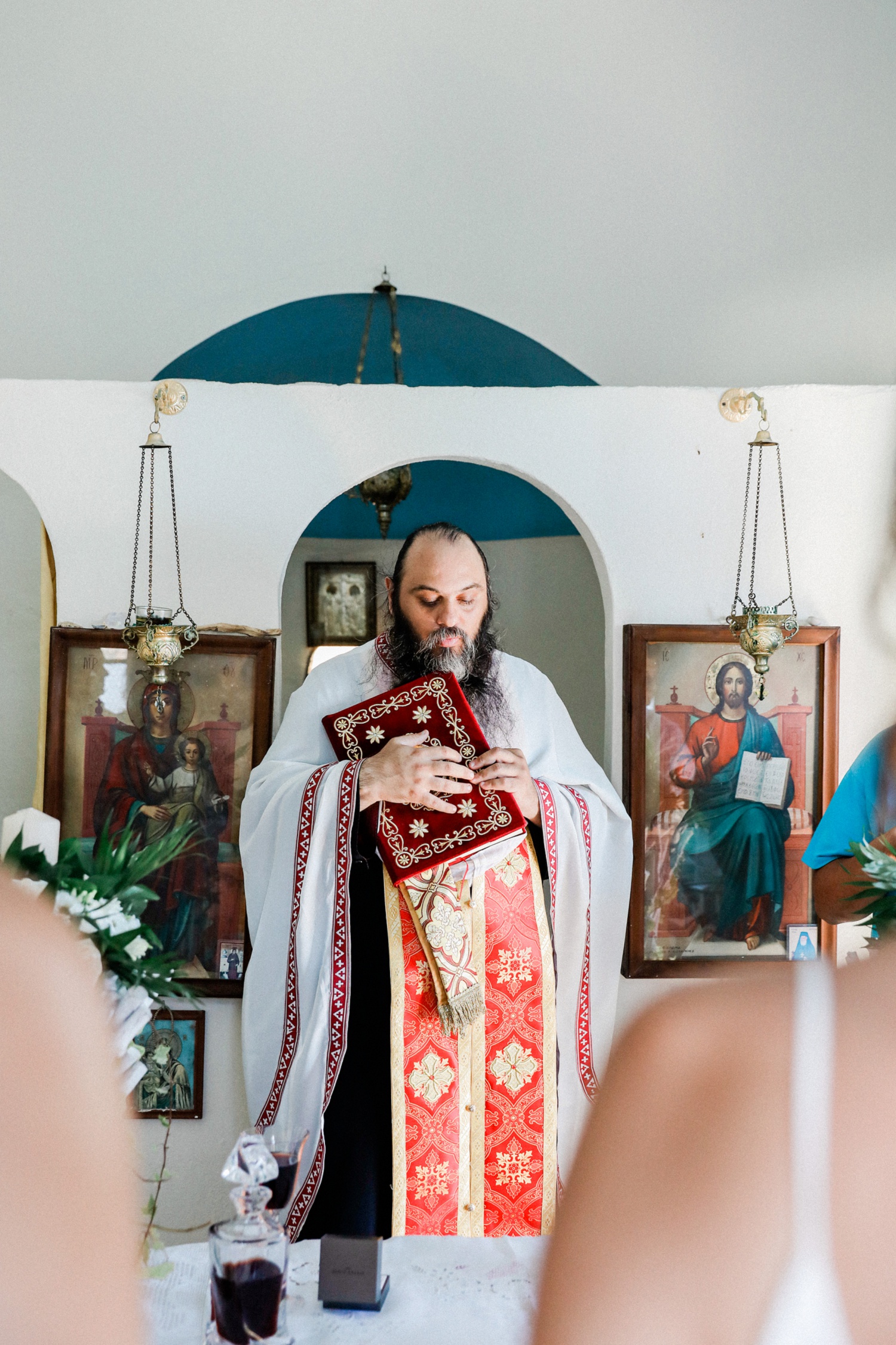 Priest holds a Bible during a Greek wedding ceremony on Ithaca island