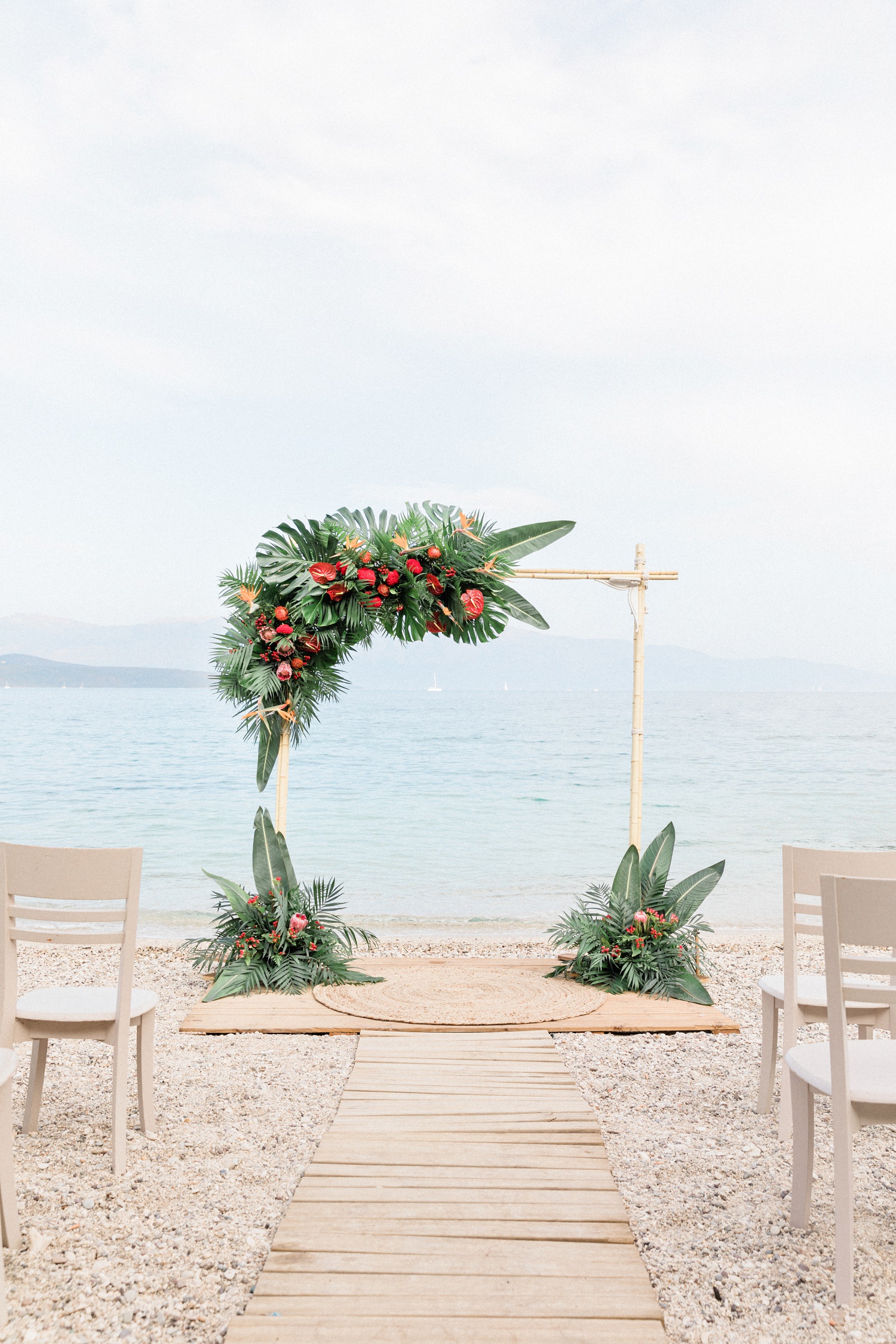 Tropical wedding arch on the beach in Lefkada with ceremony seating
