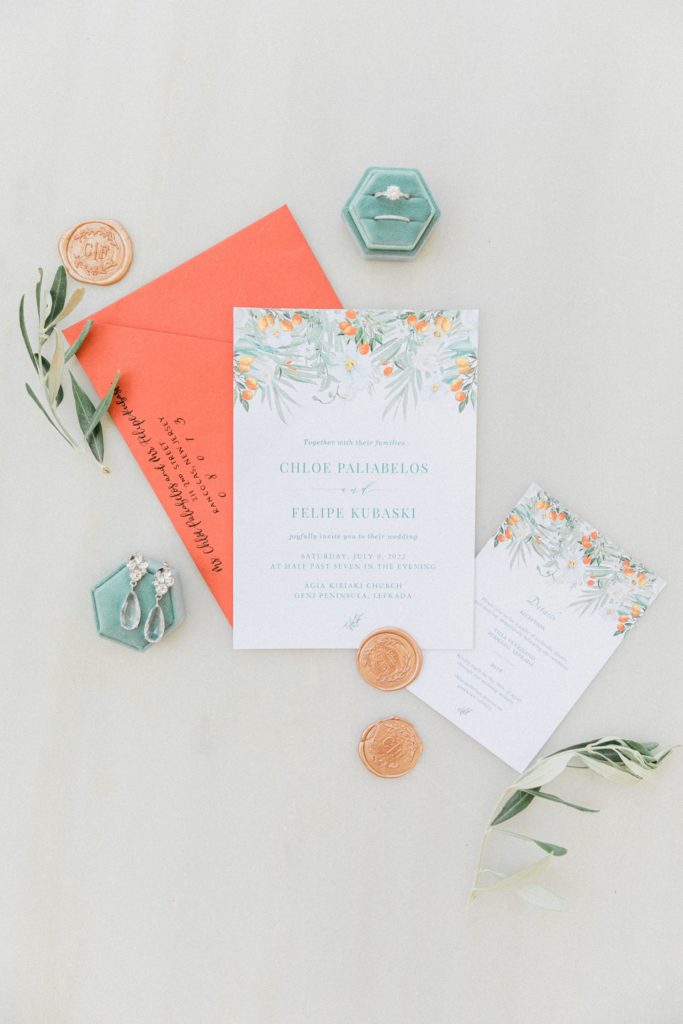 Orange and olive wedding invitation styled with gold wax seals, diamond jewellery and teal ring box